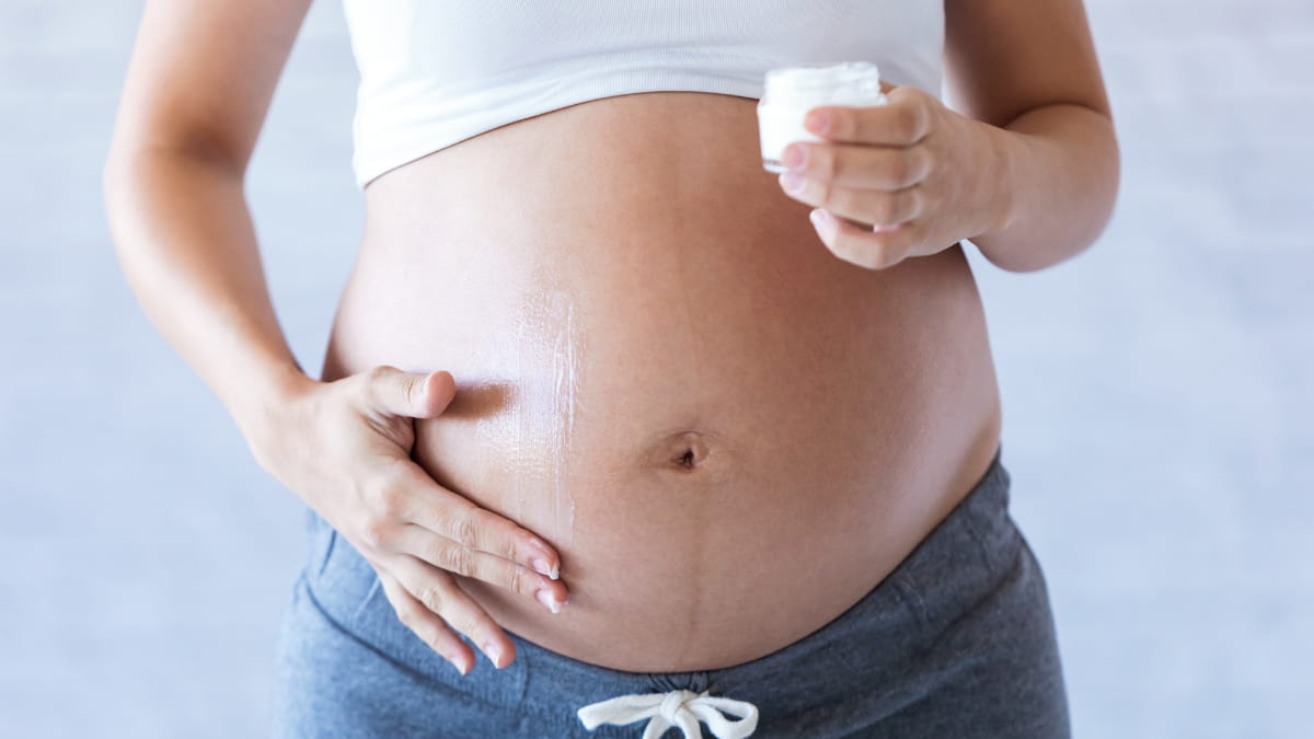 Pregnant Mom Rubbing Belly With Belly Balm As A Form Of Self Care